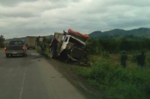 Camión de carga termina volcado al chocar contra volteo