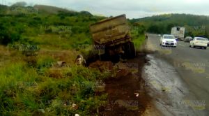 Camión de carga termina volcado al chocar contra volteo