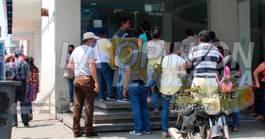 A media calle hacen fila para entrar al banco