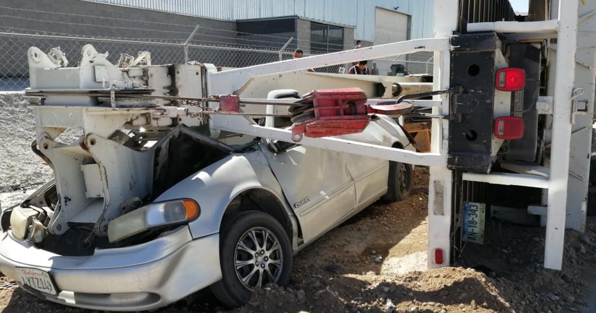 Grúa choca y vuelca contra dos autos; conductor sufre lesiones