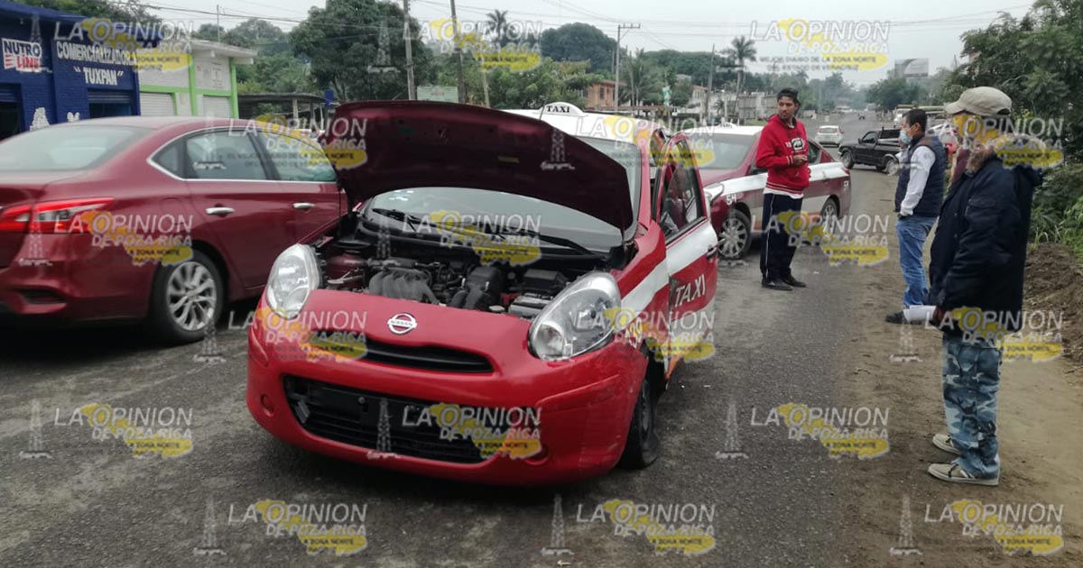 Intenta rebasar y choca con un taxi