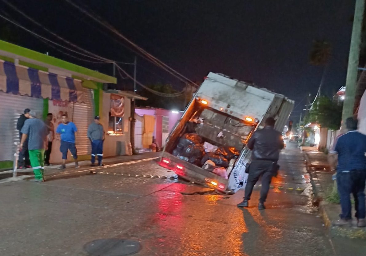 Camión de basura queda atrapado en socavón